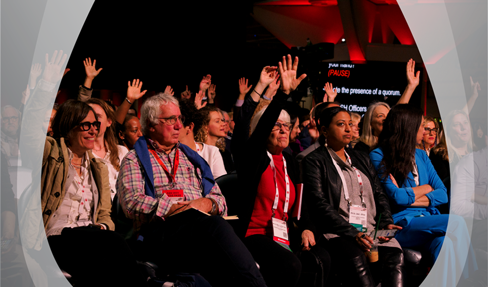 A group of people at the ASH annual meeting  with some raising their hands