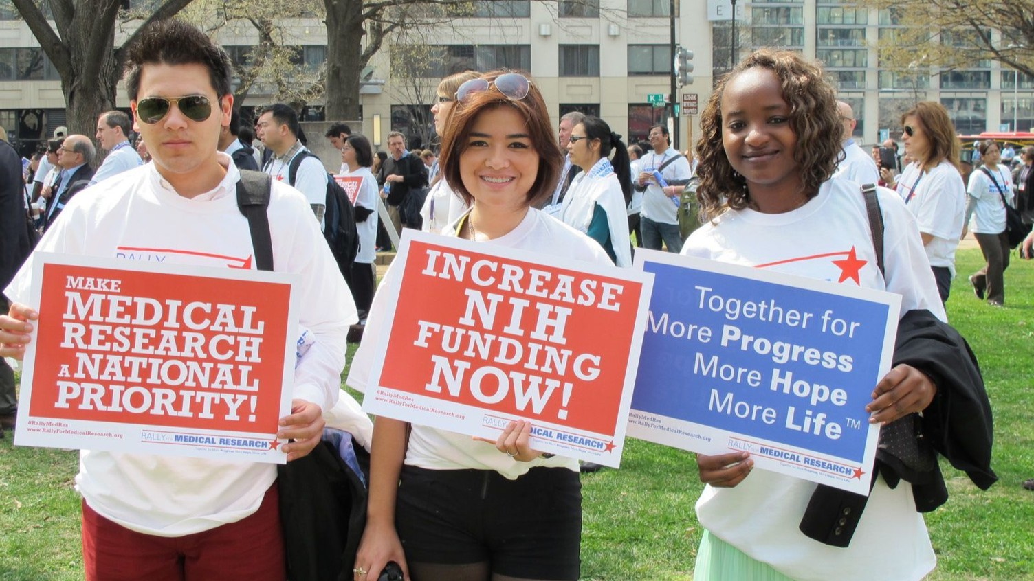 members at rally for NIH with signs