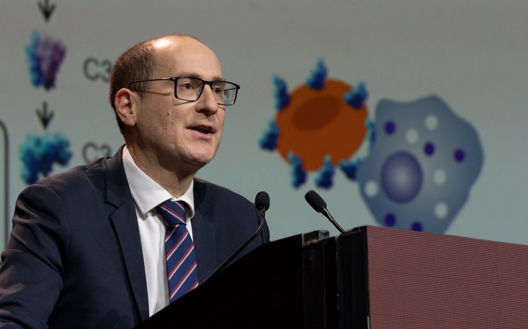 A speaker presents a late breaking abstract