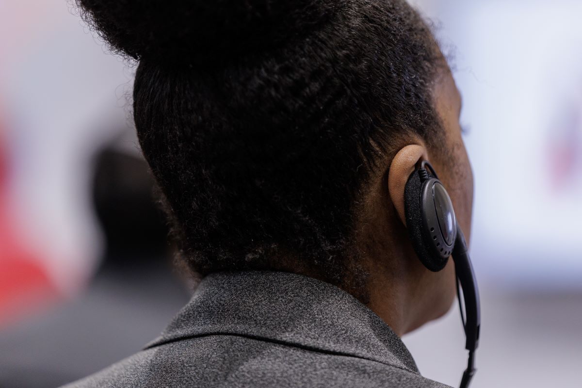An attendee listens to a session using an audio device provided at the meeting.