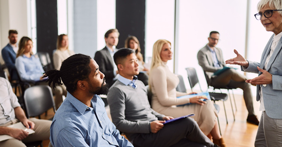 A photo of group of diverse people during a training with a speaker