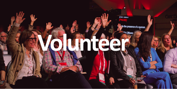 Volunteer-A group of people raising their hands at an event