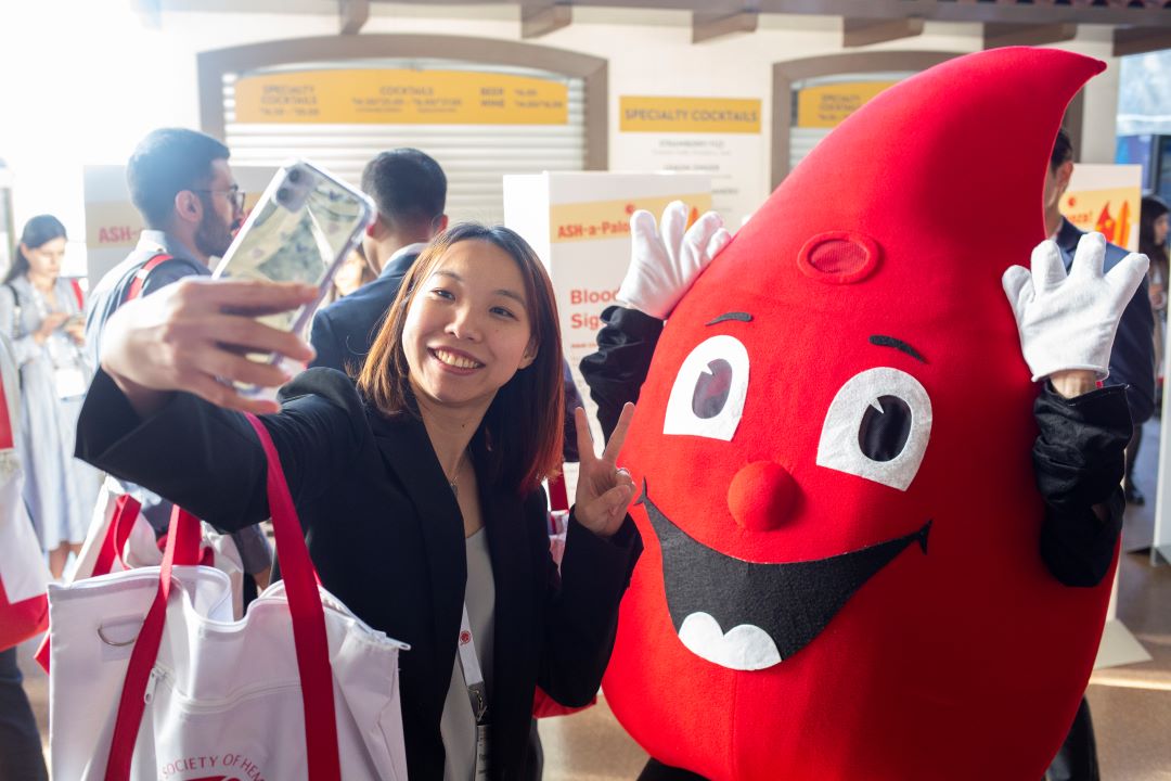 A trainee poses for a photo with ASH's mascot, Red.